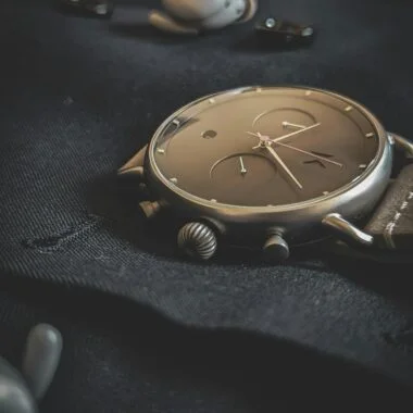 Stylish wristwatch lying on a dark fabric, emphasizing luxury and elegance.